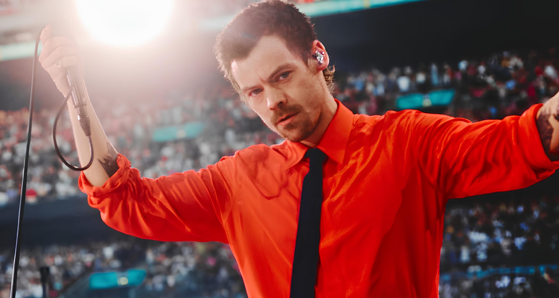 Harry Styles performing at Wembley in a red Valentino shirt and black tie on the Together, Together tour