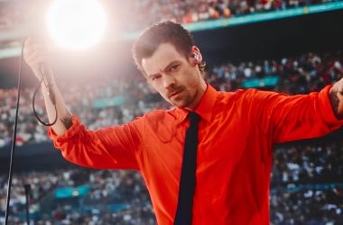 Harry Styles performing at Wembley in a red Valentino shirt and black tie on the Together, Together tour