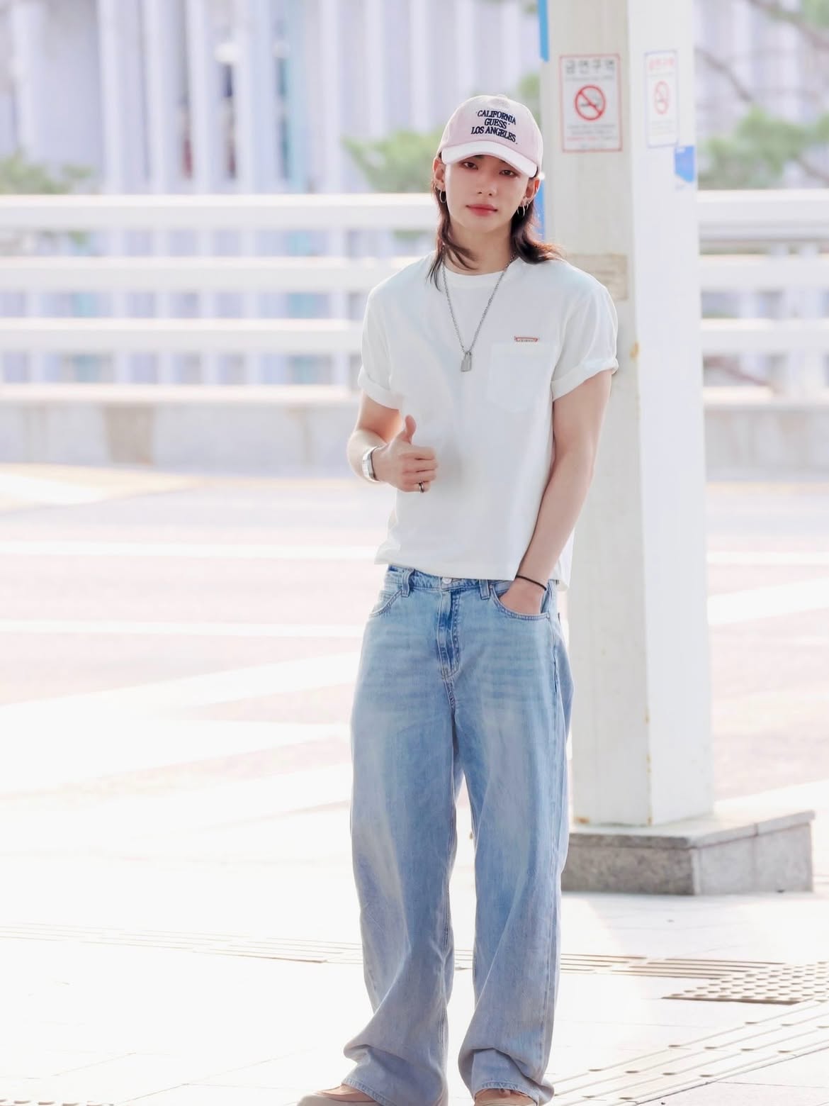 K-pop idol Hyunjin of Stray Kids wearing a GUESS look with a pink cap at Incheon International Airport