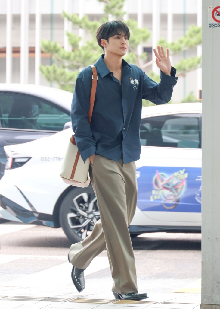 Mingyu of SEVENTEEN wearing a Dior Flower Bee Embroidery Shirt, twill chinos, Normandie Tote and Monk Derby Shoes at the airport