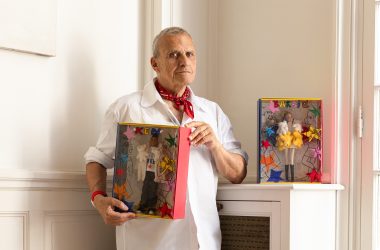 Jean-Charles de Castelbajac holding Barbie and Ken dolls in his studio