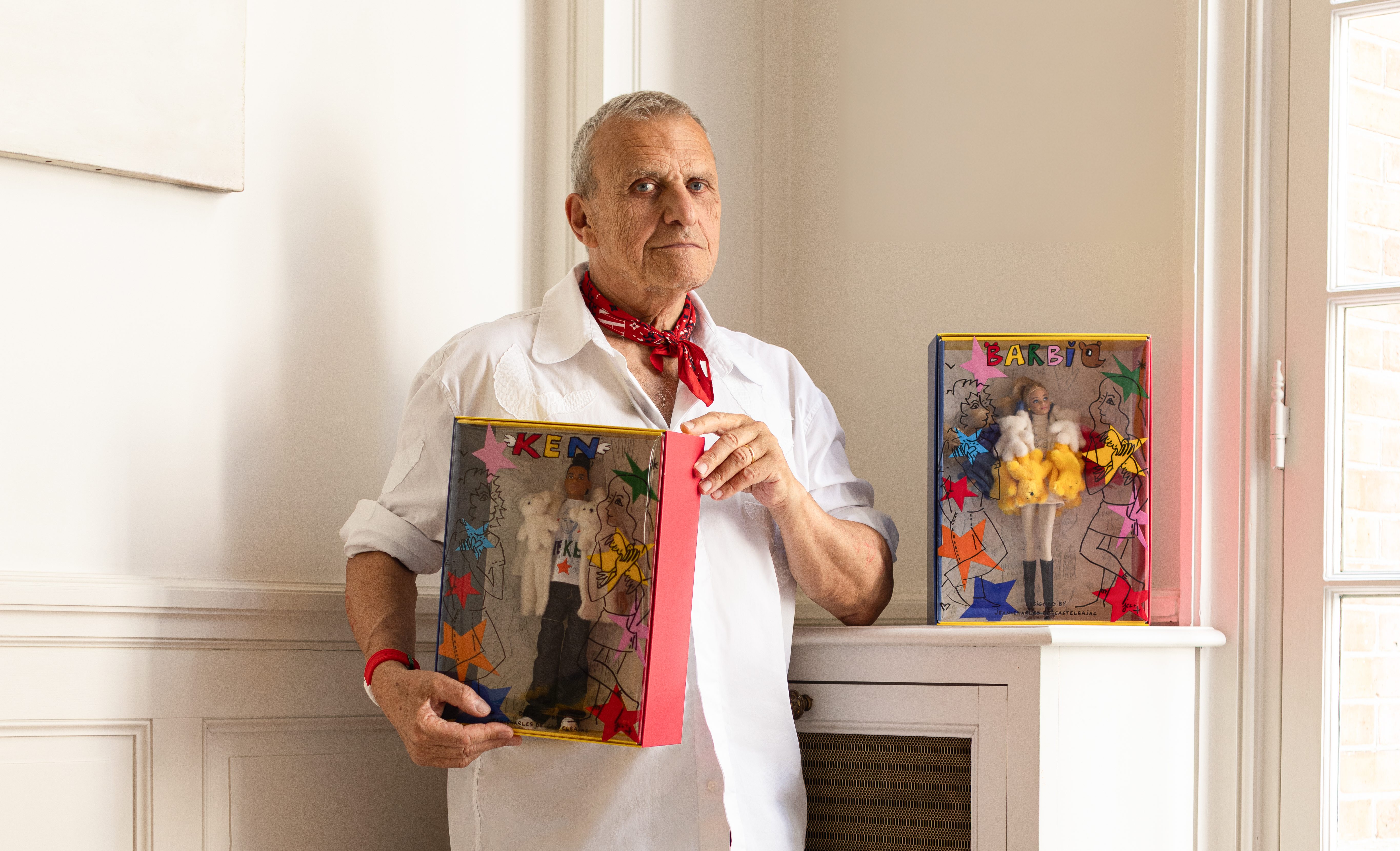 Jean-Charles de Castelbajac holding Barbie and Ken dolls in his studio